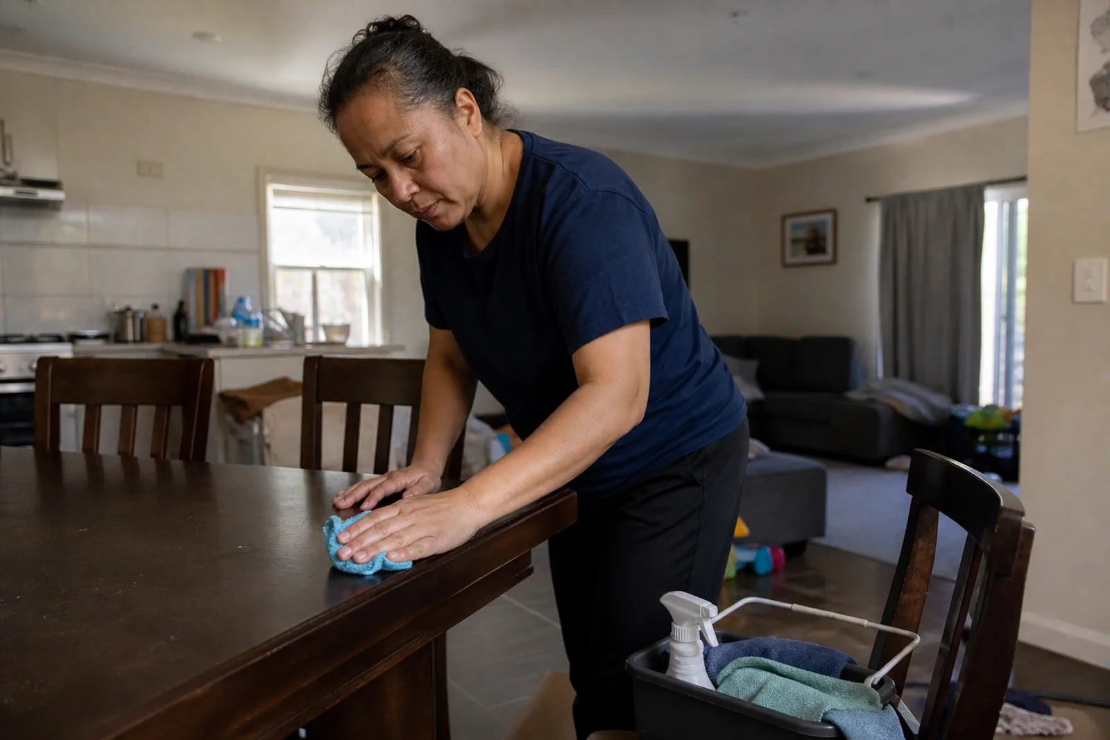 Cleaner wiping a dining table in an everyday family home